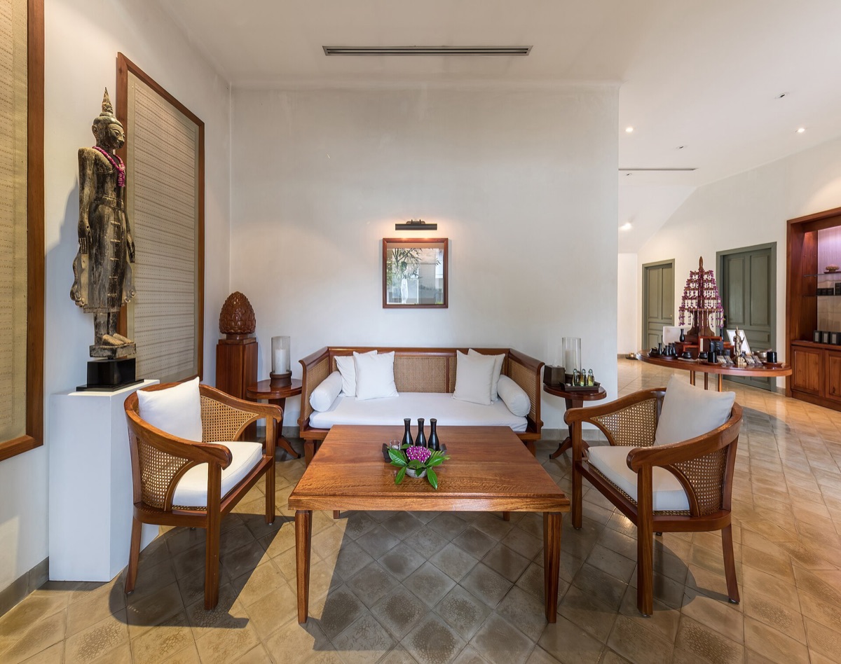 Reception lounge of a spa with armchairs, warm wood, and soft daylight